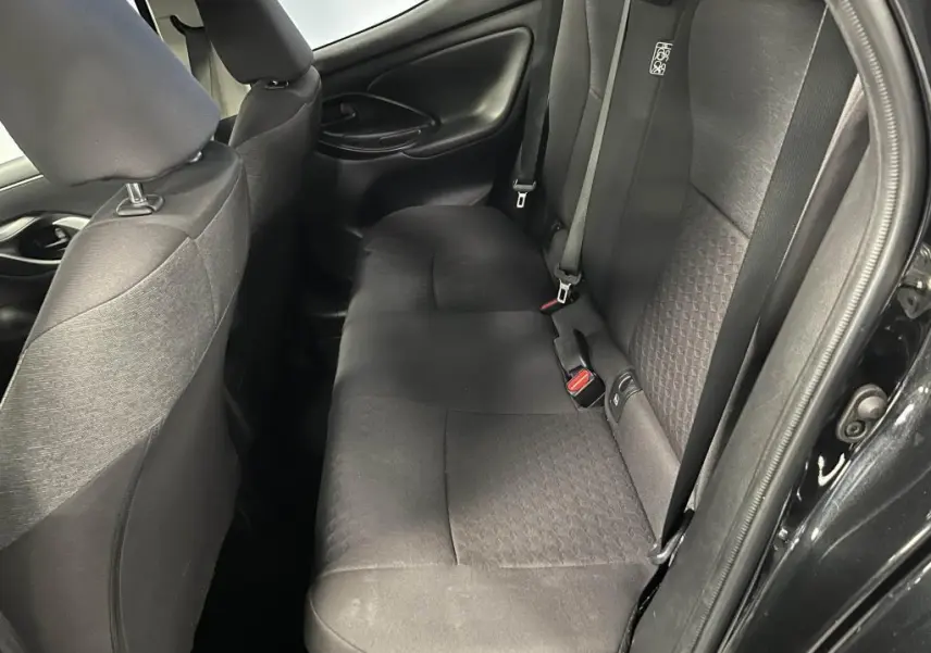 Vue côté droit des sièges arrière noirs en tissu de la Mazda2 2023 avec ceinture de sécurité et porte ouverte.