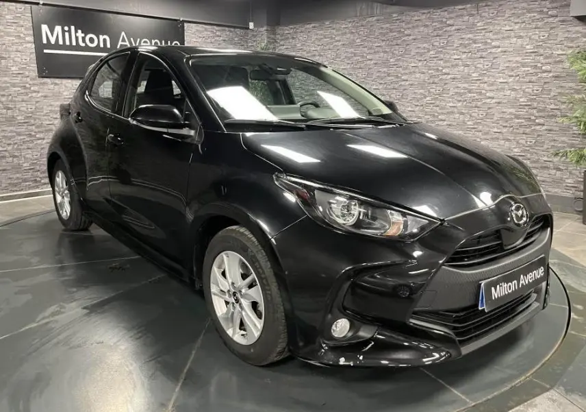 Vue 3/4 avant gauche de la Mazda2 noire 2023 avec calandre noire et jantes alliage argentées.