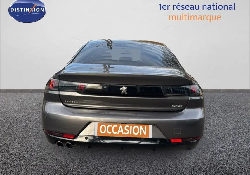 Vue arrière d'une Peugeot 508 gris platinium, avec double sortie d'échappement et logo central visible.