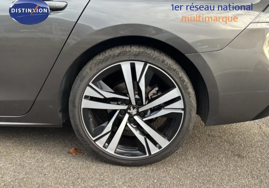 Gros plan sur la roue arrière droite d'une Peugeot 508 gris platinium, avec jante alliage noire et argentée.