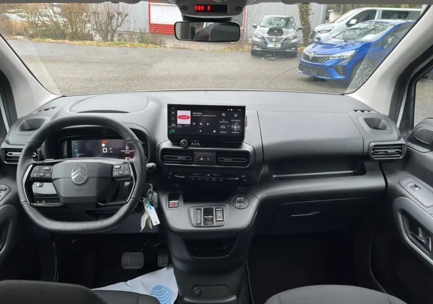 Vue intérieure avant du Citroën Berlingo Kaolin White 2026, tableau de bord avec écran tactile et volant multifonctions cuir.