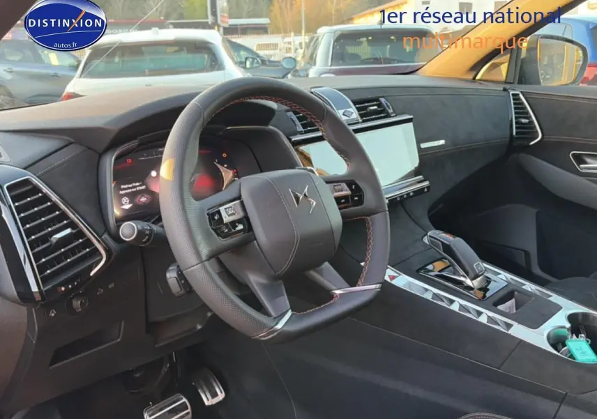 Vue intérieure côté conducteur du DS7 1.5 BlueHDi 130 noir, volant cuir avec surpiqûres rouges et écran tactile central.