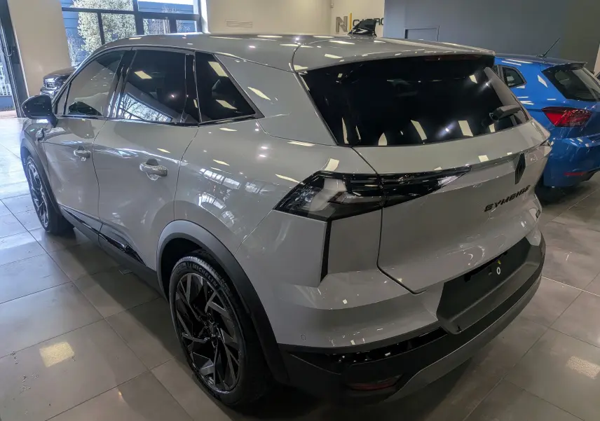 Vue 3/4 arrière droite du Renault SYMBIOZ gris Rafale avec jantes noires et vitres teintées en showroom.