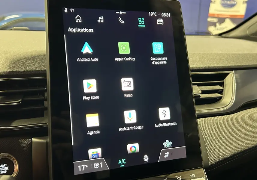 Vue intérieure centrée sur l'écran tactile vertical du tableau de bord du Renault Captur bleu Iron, affichant les applications connectées.
