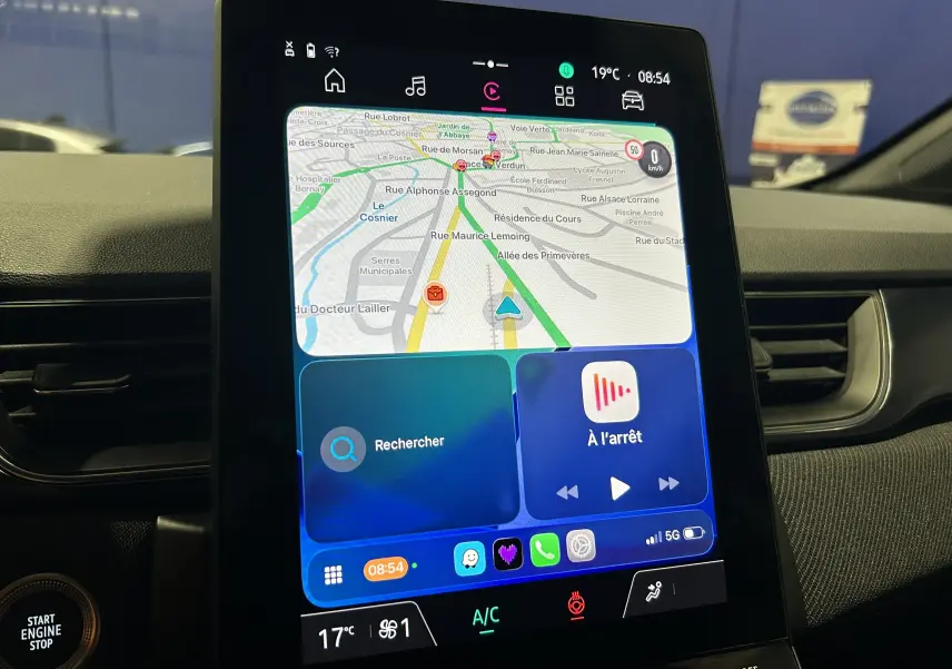 Écran tactile central du tableau de bord du Renault Captur bleu Iron, affichant la navigation GPS et les commandes multimédia.