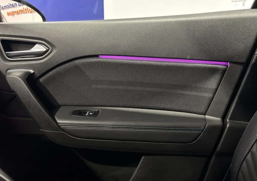 Vue intérieure côté droit de la porte du Renault Captur II Ph.2 en noir avec éclairage d’ambiance violet et bouton de lève-vitre.