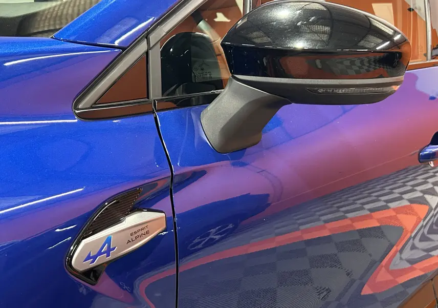 Détail du rétroviseur noir et de l'aile avant gauche bleu iron du Renault Captur II Ph.2 E-Tech Esprit Alpine.