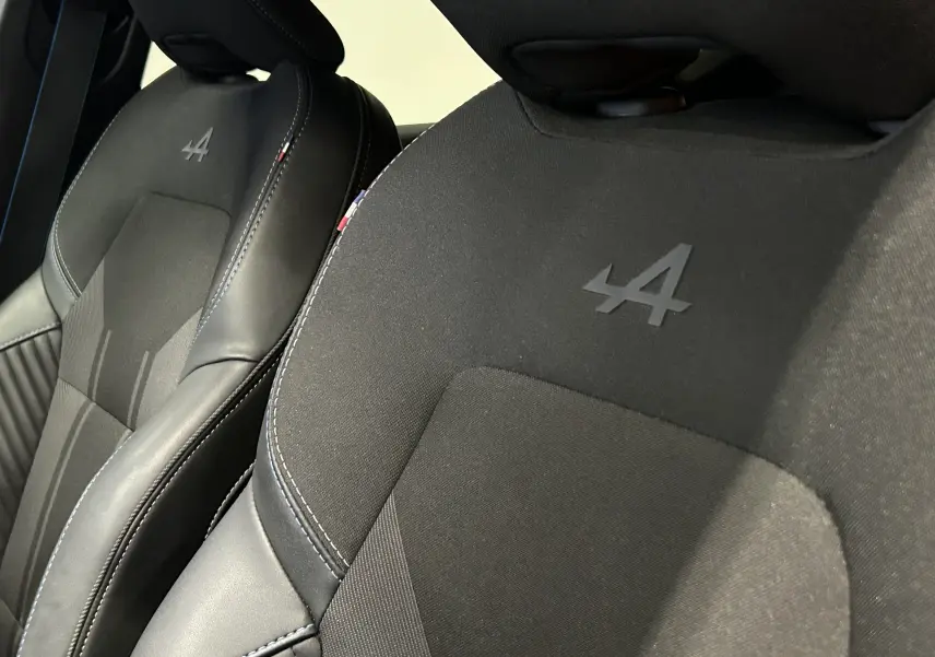 Gros plan sur les sièges avant noirs avec logo Alpine embossé, intérieur du Renault Captur II Ph.2 E-Tech.
