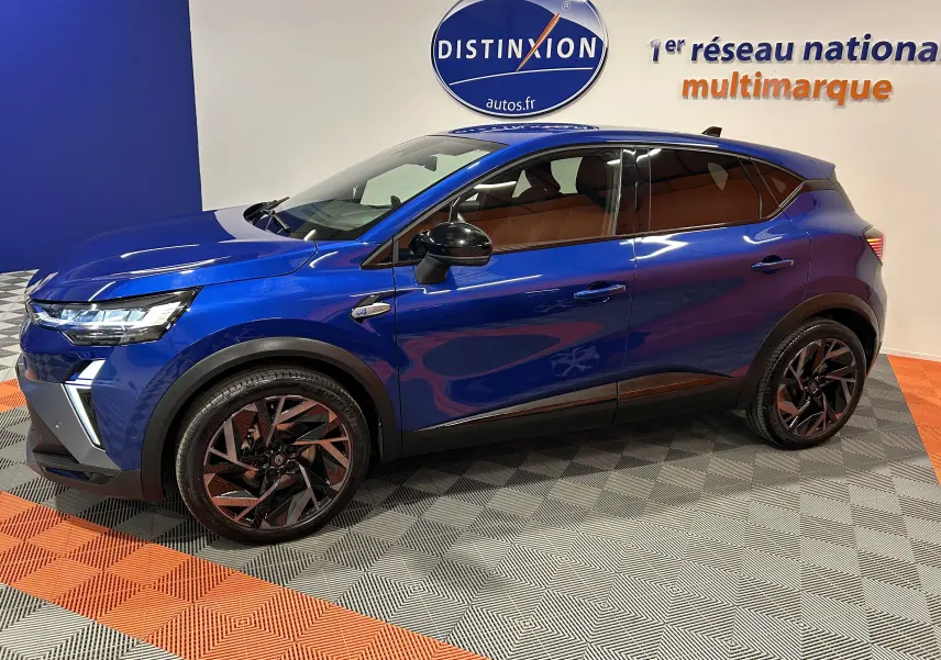 Renault Captur II Ph.2 E-Tech hybride bleu Iron en vue latérale gauche, jantes noires et intérieur marron visible.