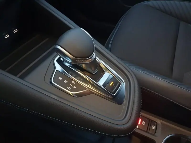 Gros plan sur la commande de boîte automatique noire du Renault Captur 1.6 E-Tech, avec siège cuir gris visible à droite.