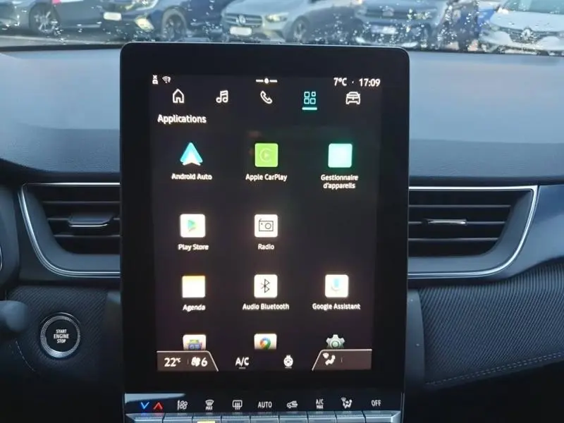 Vue intérieure centrée sur l'écran tactile multifonction du Renault Captur 2025, avec tableau de bord noir et bouton start visible.