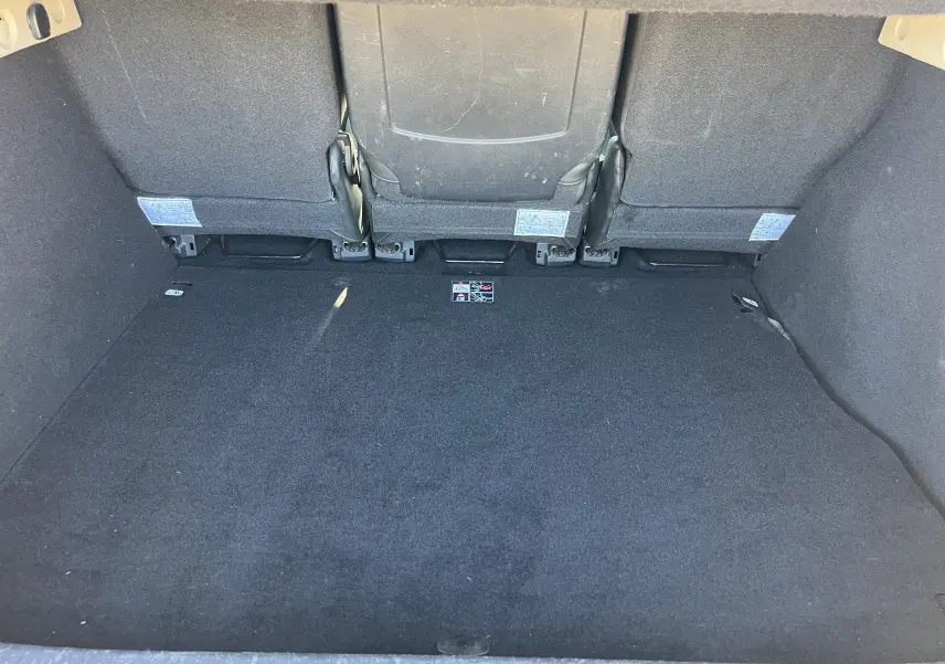 Coffre spacieux noir du Renault Scenic III 1.5 DCI 110 CH BOSE EDC vu de l'arrière avec sièges rabattus.