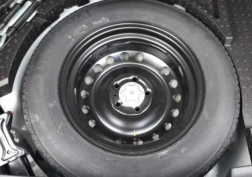 Gros plan sur la roue de secours noire dans le coffre du Nissan Qashqai blanc 2020.