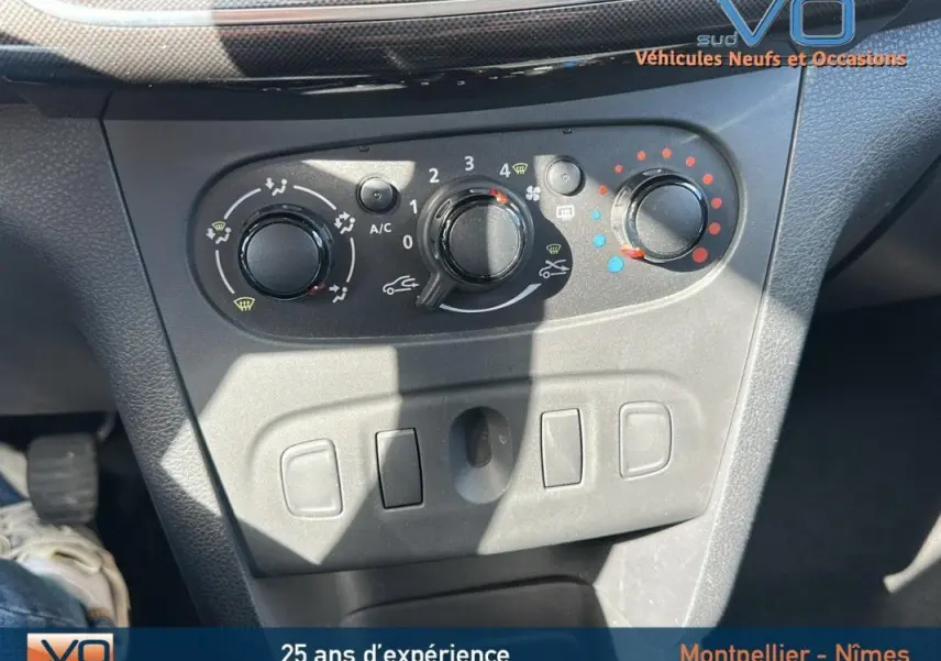 Vue rapprochée de la console centrale de la Dacia Logan MCV gris clair, montrant les commandes de climatisation manuelle.