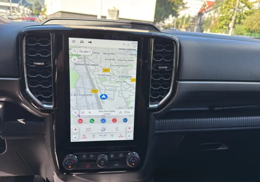 Vue rapprochée de la console centrale du Ford Ranger 2025 avec écran tactile de navigation et commandes climatisation.