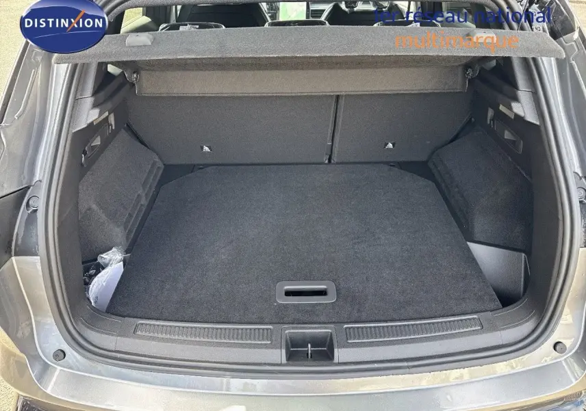 Coffre ouvert vu de l'arrière d'un Renault Austral gris schiste métal avec toit noir, montrant un espace de chargement propre.