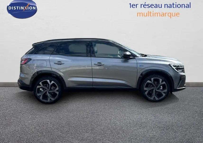 Profil côté gauche d'un Renault Austral 2024 gris schiste métal avec toit noir, roues alliage et détails hybrides visibles.
