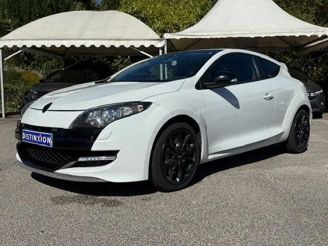 Renault Mégane III Coupé 2.0T RS blanc nacré en 3/4 avant, jantes noires et détails noirs contrastants.
