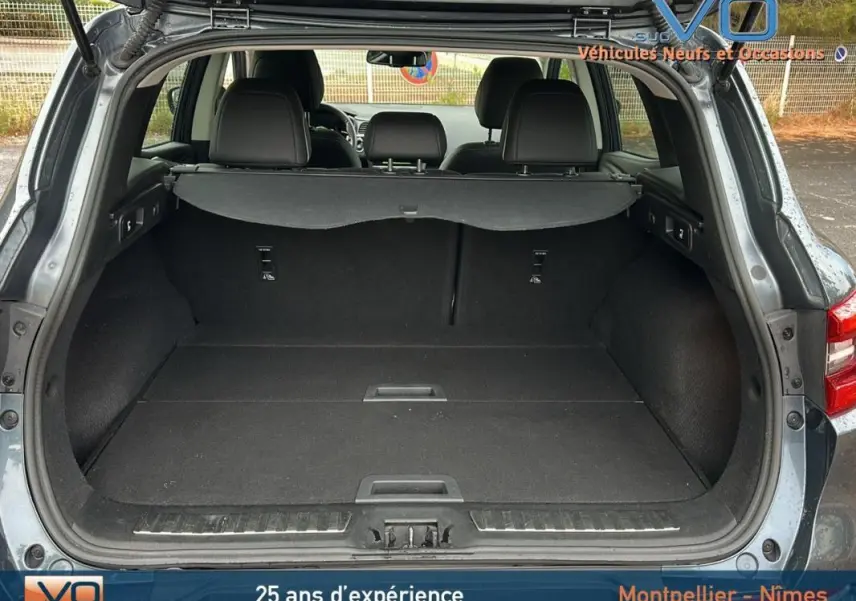 Coffre ouvert d'un Renault Kadjar gris 2019, vue arrière montrant l'espace de chargement et les sièges arrière rabattables.