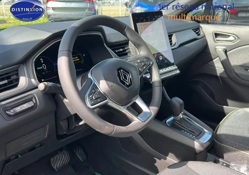 Vue intérieure côté conducteur du tableau de bord et volant du Renault Captur 1.6 e-tech hybride 2025 avec écran tactile vertical.