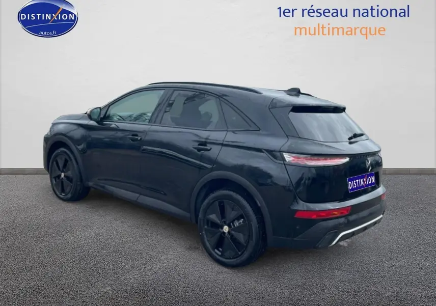 Vue 3/4 arrière droite du SUV DS7 noir brillant avec jantes noires et feux arrière LED allumés.