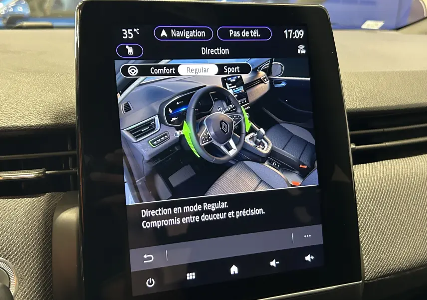 Écran tactile central affichant l'intérieur moderne de la Renault Clio V gris schiste avec tableau de bord et volant multifonction.