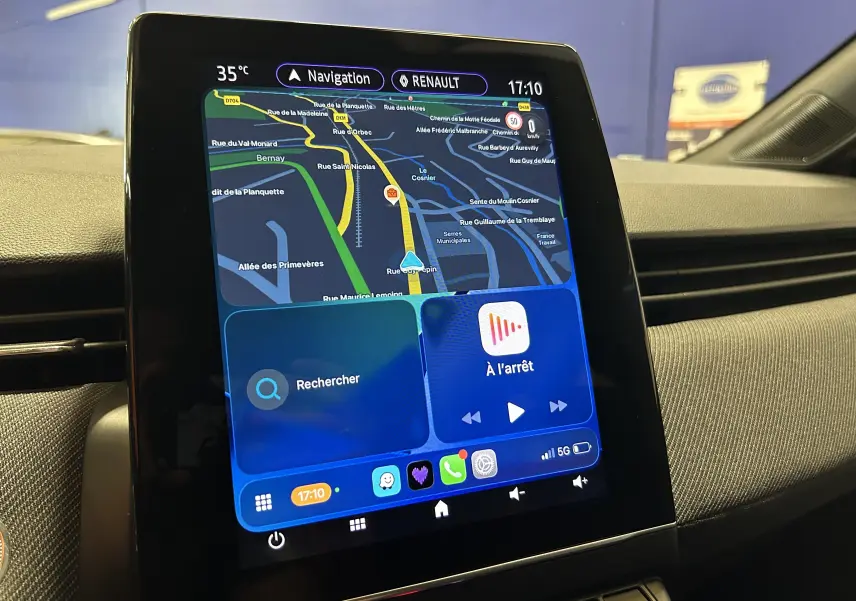 Écran tactile central du tableau de bord Renault Clio V gris schiste, affichant la navigation GPS en intérieur.