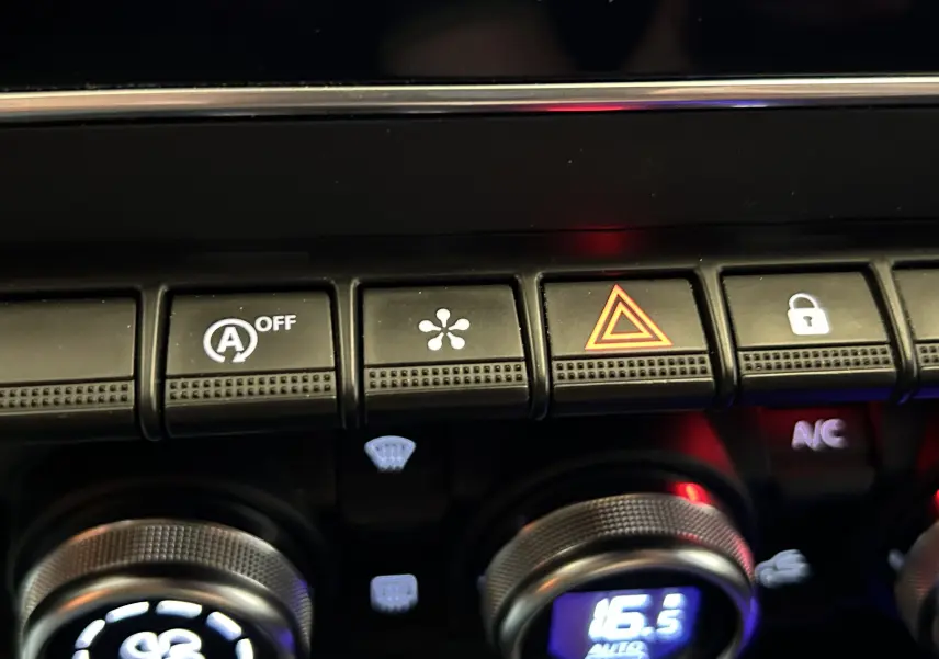 Gros plan sur les commandes de climatisation et boutons de fonction du tableau de bord intérieur de la Renault Clio V gris schiste.