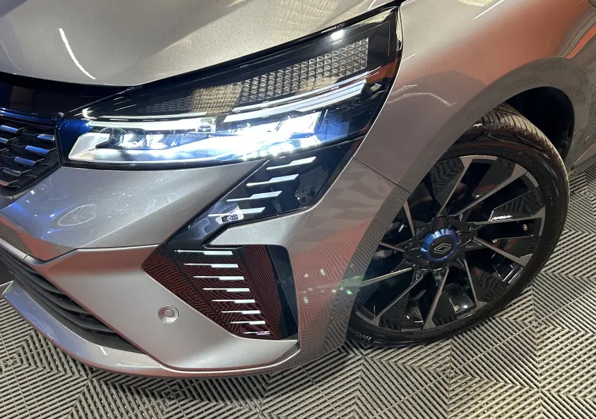Gros plan sur l’avant droit gris schiste de la Renault Clio V TCe 90 Esprit Alpine avec phares LED et jante noire brillante.