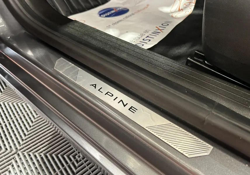 Gros plan sur la plaque de seuil de porte ALPINE sur la Renault Clio V gris schiste, côté conducteur.