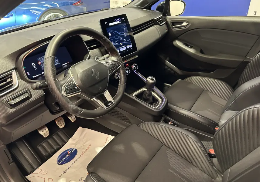 Vue intérieure côté conducteur de la Renault Clio V TCe 90 Esprit Alpine avec volant multifonction et écran tactile vertical.