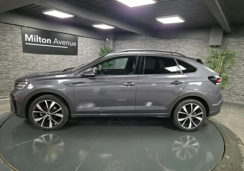 Volkswagen Taigo gris foncé vue de profil côté gauche, avec jantes alliage noires et toit noir.