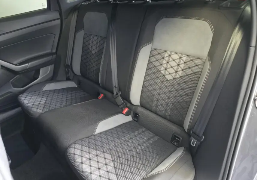 Vue intérieure côté arrière droit montrant la banquette arrière gris foncé avec motifs géométriques et ceintures de sécurité.