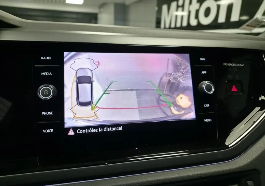 Écran tactile intérieur affichant la caméra de recul du Volkswagen Taigo gris foncé avec aides au stationnement activées.