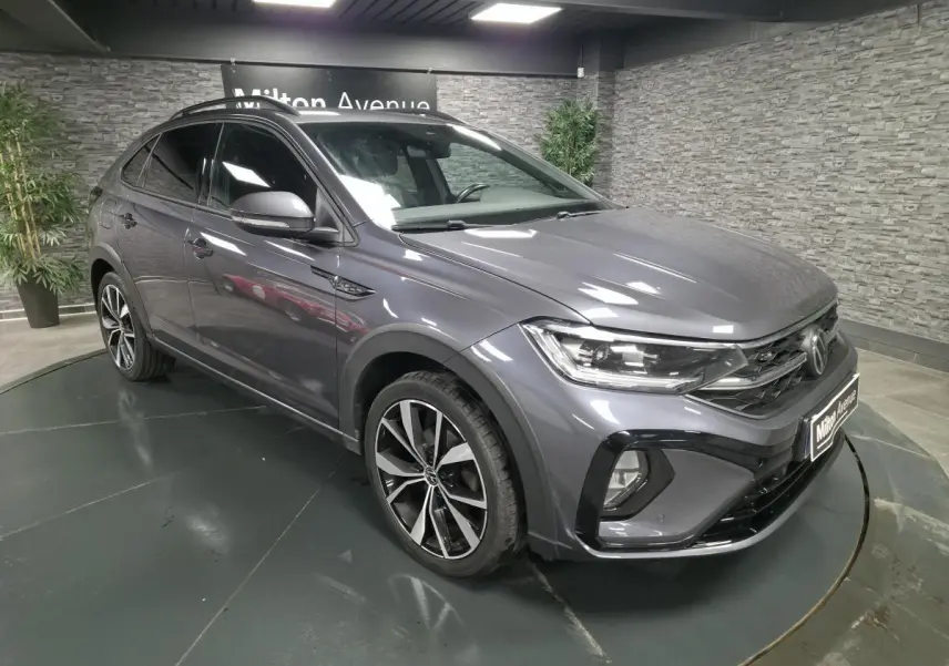 Volkswagen Taigo gris foncé en 3/4 avant droit avec jantes alliage noires et détails R-Line visibles.