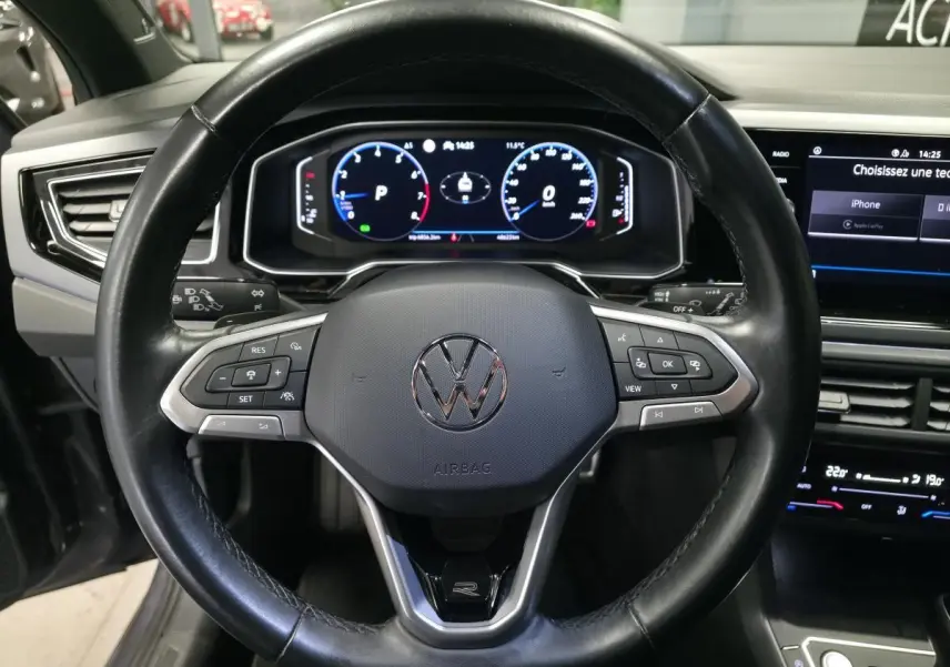 Vue rapprochée du volant cuir noir multifonctions et du tableau de bord numérique du Volkswagen Taigo gris foncé R-Line.