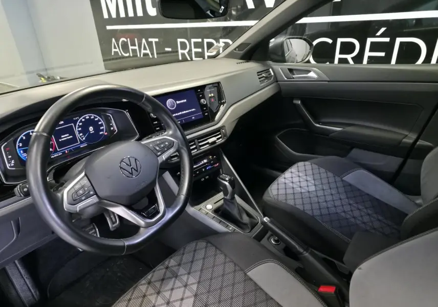 Intérieur avant du Volkswagen Taigo gris foncé, vue côté conducteur avec volant multifonctions et tableau de bord digital.