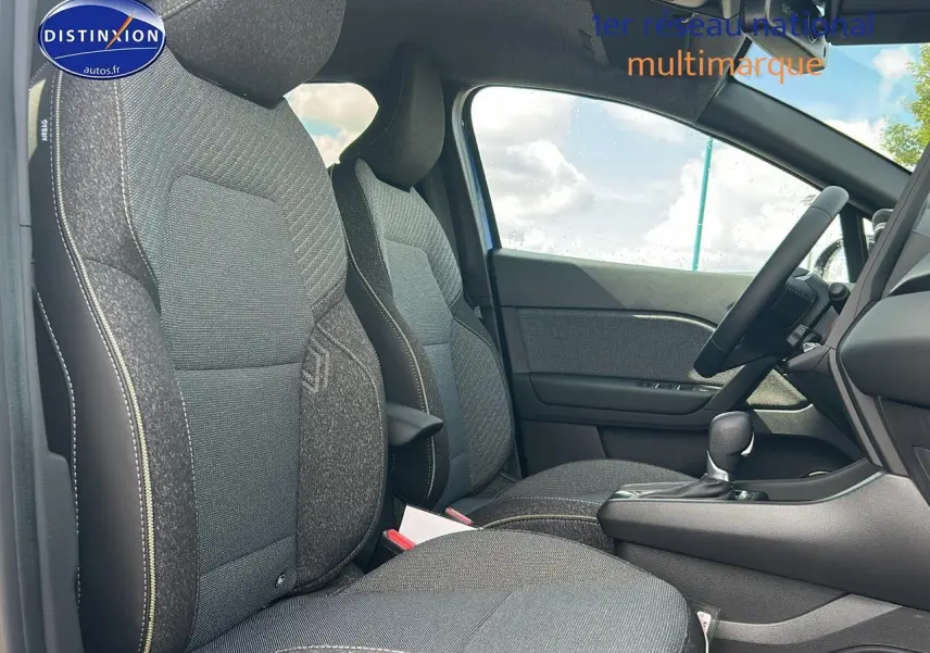Vue intérieure côté droit du Renault Captur 2025, sièges tissu gris avec accoudoir central et levier de boîte automatique.
