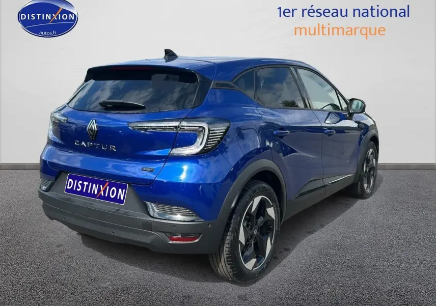 Vue 3/4 arrière droite du Renault Captur bleu iron avec jantes alliage et vitres teintées.