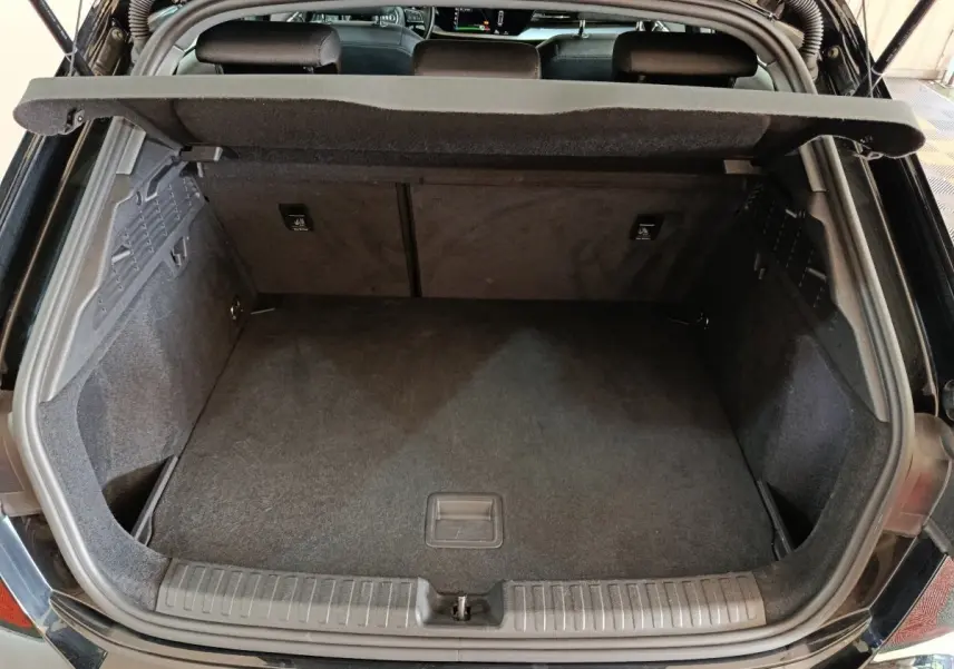 Vue arrière du coffre ouvert d'une Audi A3 35 TDI noire, montrant un espace de rangement propre et spacieux.