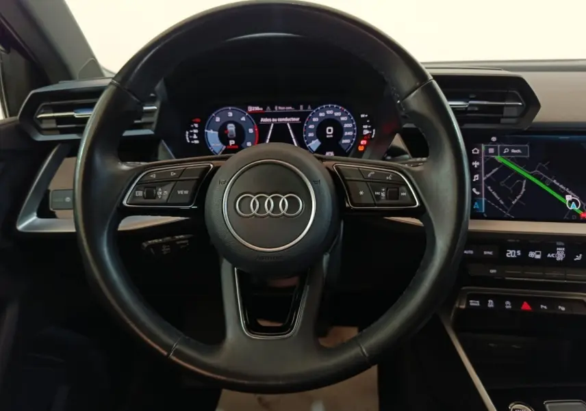 Vue centrée sur le volant cuir noir d’Audi A3 35 TDI 2023 avec tableau de bord digital et écran tactile de navigation.