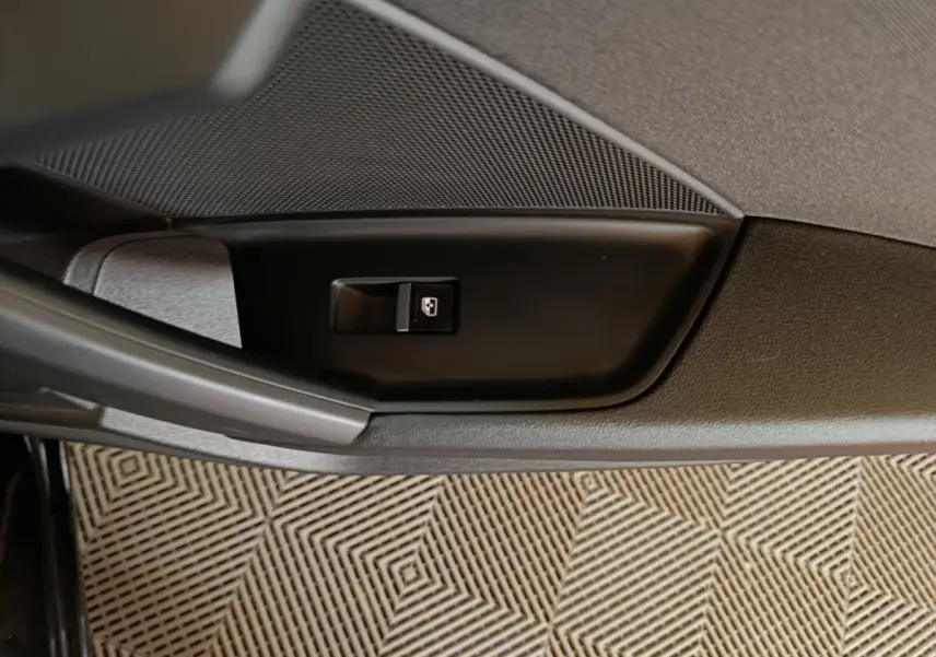 Gros plan sur le bouton de verrouillage des portes côté gauche de la porte intérieure d’une Audi A3 noire 2023.