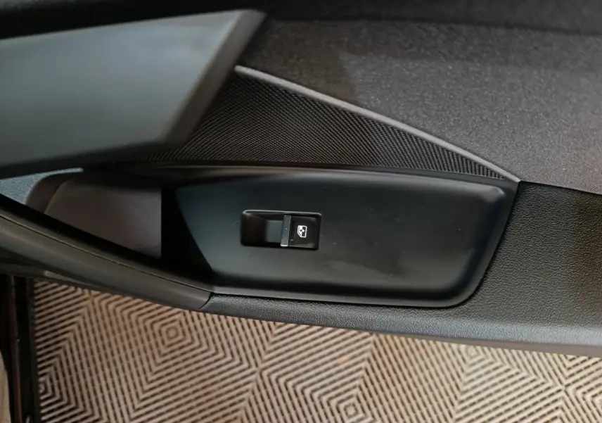 Bouton de commande de vitre électrique sur la porte intérieure noire d'une Audi A3 35 TDI 2023.