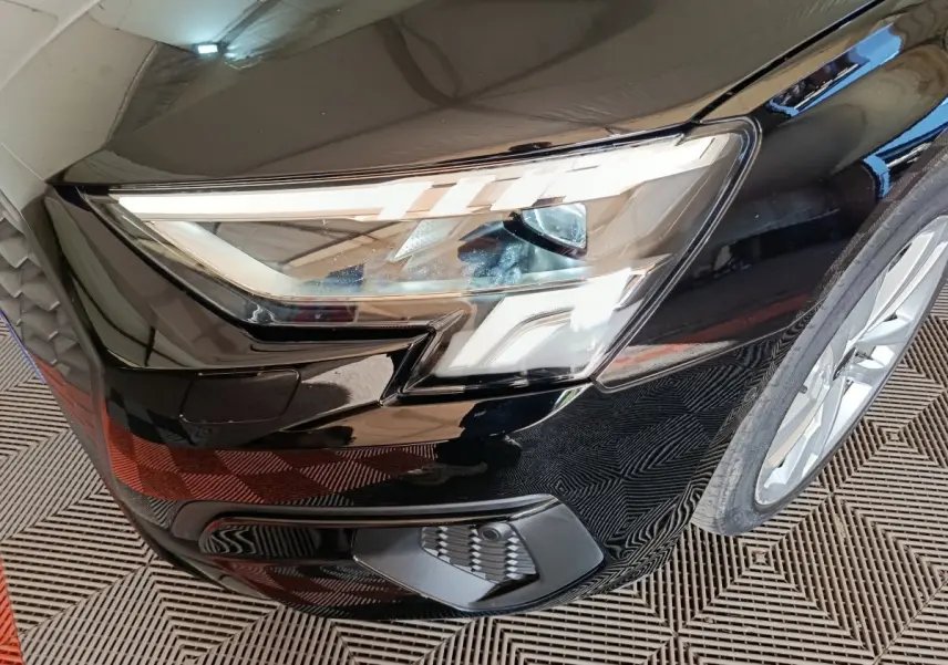 Gros plan sur le phare avant droit noir brillant de l’Audi A3 35 TDI 150 S tronic Business Line 2023.