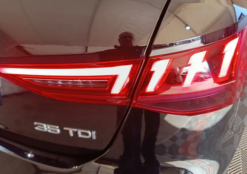 Gros plan sur le feu arrière droit rouge et blanc d'une Audi A3 35 TDI noire, avec logo 35 TDI visible sur le coffre.