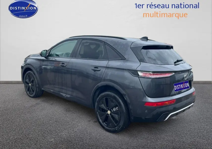 Vue 3/4 arrière droite d’un DS7 gris titane avec jantes noires et feux arrière LED fins.