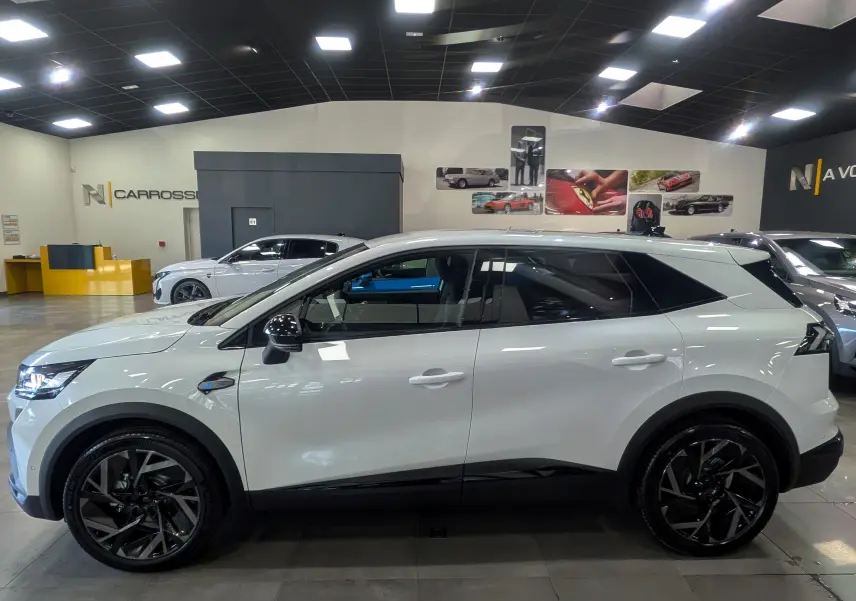 Vue de profil côté gauche du Renault SYMBIOZ blanc nacré, avec jantes noires et détails noirs contrastants.