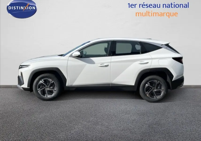 Vue de profil côté gauche d’un Hyundai Tucson blanc Atlas 2026 avec jantes alliage et lignes anguleuses marquées.