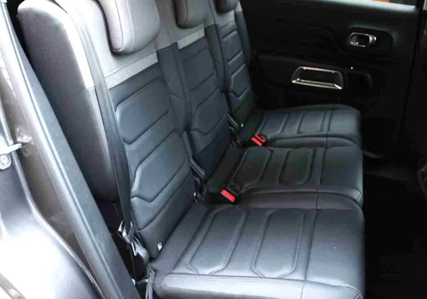 Vue latérale des sièges arrière en cuir noir du Citroën C5 Aircross gris platinium, avec ceinture et appuie-têtes visibles.