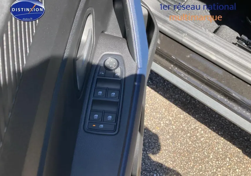 Vue rapprochée de la porte avant gauche du Dacia Duster noir, montrant les commandes électriques des vitres.